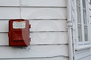 An old emergency telephone on a traditional wooden house. Gamle Stavanger, the old city. Stavanger. Rogaland county. Norway