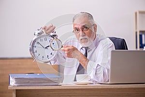 Old male employee in time manegement concept photo