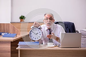 Old male employee in time manegement concept photo