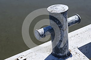 Old empty rusty mooring bollard