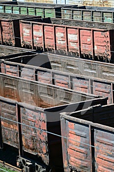 Old empty rusty train cars on rails in summer day