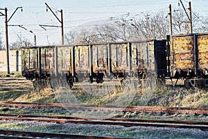 Old empty rusty train cars on rails in sunny day. Industrial crisis