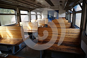 Old empty wagon of train. Wooden seats in an empty coach of train