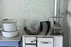 Old enameled white kitchen stove with utensils