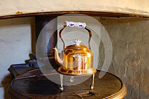 Old English copper teapot on an oven