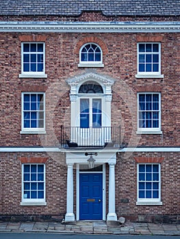 Old European brick facade with windows and columns in a symmetric