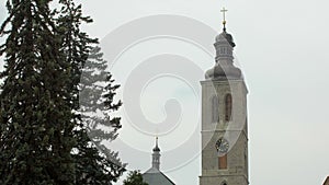 Old european clock tower in small city against cloudy sky