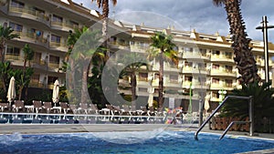 Old european hotel with pool and palms.