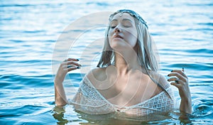 Pagan rituals in lake, young woman in white photo