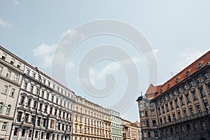 Old European street, solid building, houses, lot of Windows with decorative small balconies, red roof tiles, blue sky