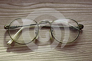 Old eye glasses on wooden background