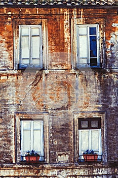 Old facade four windows home. Ancient bricks wall