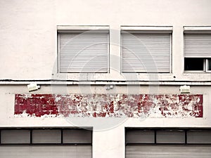 Old facade with a shabby red color, windows