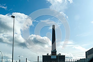 Old factory chimney on blue sky background