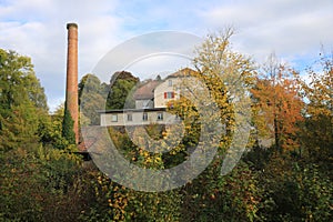 Old factory Schoenau surrounded by colorful trees