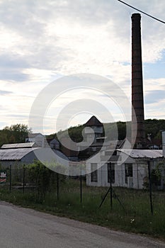Old Factory with smokestack and tower in Majdan Male Karpaty mountains near Horne Oresany, west Slovakia