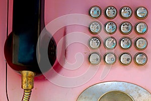 Old faded red telephone with metal buttons