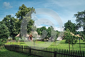 Old farm buildings and a court surrounded by trees in a countryside scenery. Zwierzyniec,