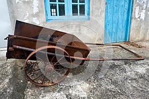 Old farm cart with two whells standing near house. photo