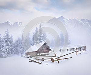 Old farm in foggy winter mountains