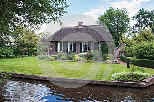 Old farm house along the canal in a small Dutch town Giethoorn