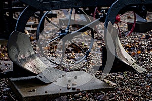 An old farm machine in a farm. Old plow on the lawn in a farm.