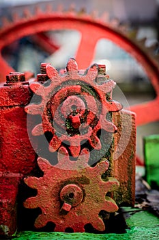 Old farm machinery on a farm. Root mechanisms and wheels in agricultural machinery from the last century.