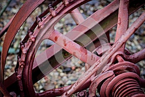 Old farm machinery on a farm. Root mechanisms and wheels in agricultural machinery from the last century.