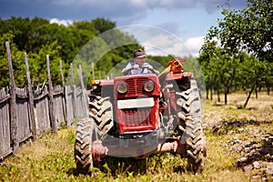 Old farmer driving his tractor