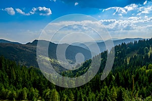 An old farmer's wooden house stands on an elephant mountain near a haystack against the backdrop of mountain peaks