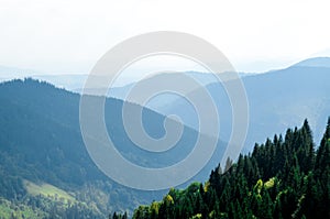 An old farmer's wooden house stands on an elephant mountain near a haystack against the backdrop of mountain peaks