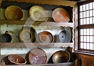 Old farmer village house.Ceramic and metal dishes. Coppers and frying pans for the center.In the wooden cupboard.