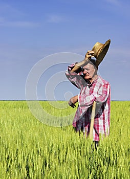 Old farmer wipe the sweat on break from work in field