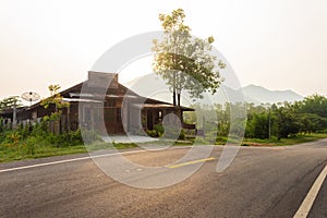 Old Farmhouse on Curve Asphalt Road Through