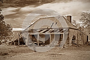 Old farmhouse ruins in sepia