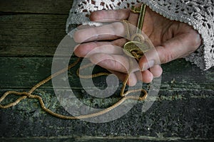 Old fashion lady holds a golden key in her hands