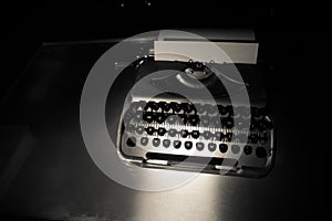 Old fashion typewritter on dark foggy background. Close up of vintage typewritter machine