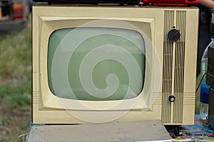 An old-fashioned analog TV in gray with a kinescope photo