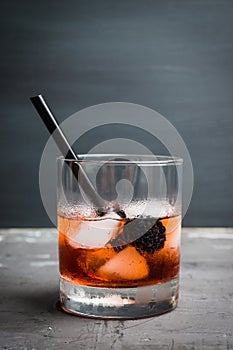 Old fashioned blackberry cocktail on the rustic background. Selective focus.