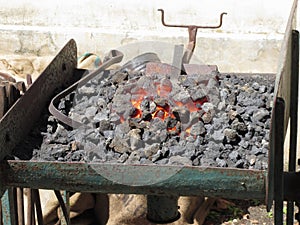 Old-fashioned blacksmith furnace with burning coals for iron work