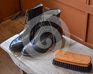 Old Fashioned Boots on a Bench with Brush