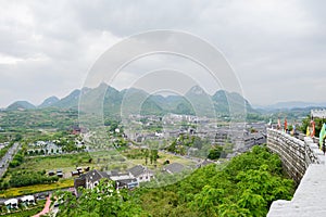 Old-fashioned buildings outside hillside wall in cloudy spring