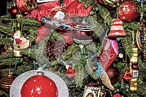 Old fashioned Christmas tree with kitchy outerspace ornaments and cowboy boot and other vintage decorations - Closeup