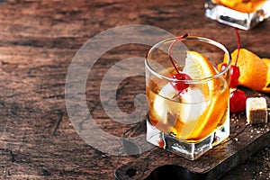 Old Fashioned - classic alcoholic cocktail with bourbon whiskey, bitter, cane sugar and ice in retro glasses on vintage bar