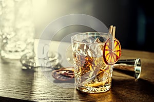 Old fashioned classic cocktail drink in crystal glass on bar counter