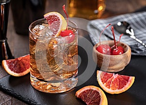 Old fashioned cocktail with cherrry and orange