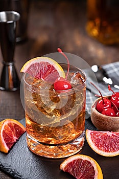 Old fashioned cocktail with cherrry and orange