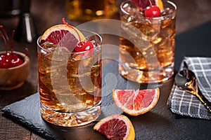 Old fashioned cocktail with cherrry and orange