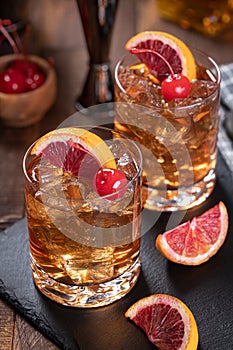 Old fashioned cocktail with cherrry and orange