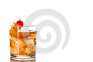 Old fashioned cocktail with orange and cherry isolated